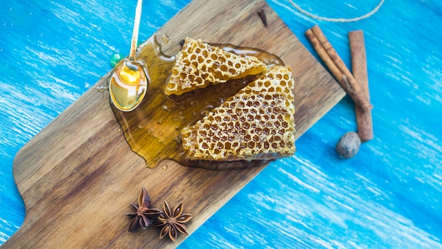 Une vue de dessus de pièces en nid d&#39;abeille et d&#39;épices sur fond texturé bleu