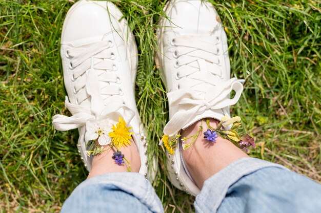 Vue de dessus des pieds de femme avec des fleurs