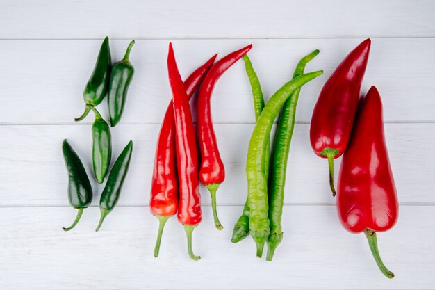 Vue de dessus des piments forts verts et rouges isolés sur blanc