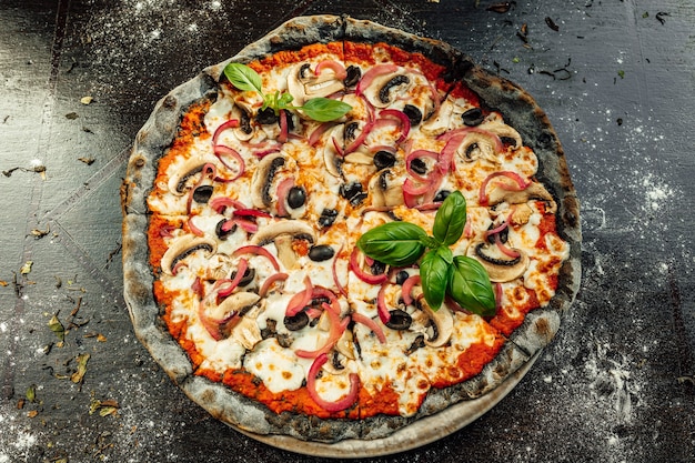 Vue de dessus d'une pizza appétissante avec pâte noire et divers légumes