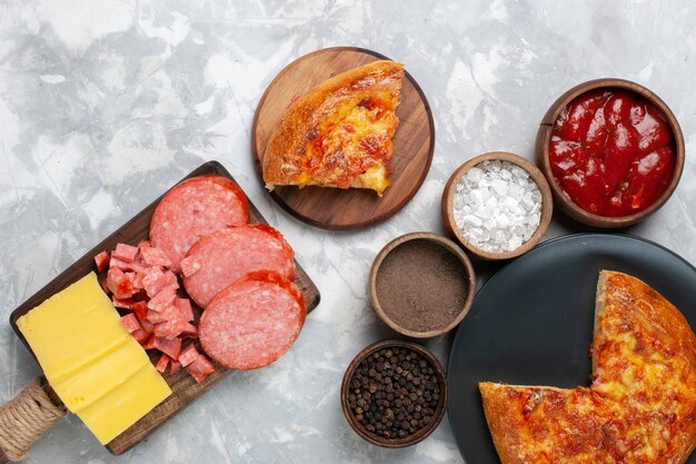 Vue de dessus pizza au fromage cuit au four avec assaisonnements sur blanc