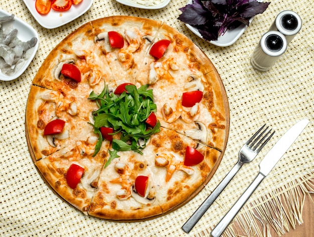 Vue de dessus pizza aux crevettes et champignons tomates et roquette