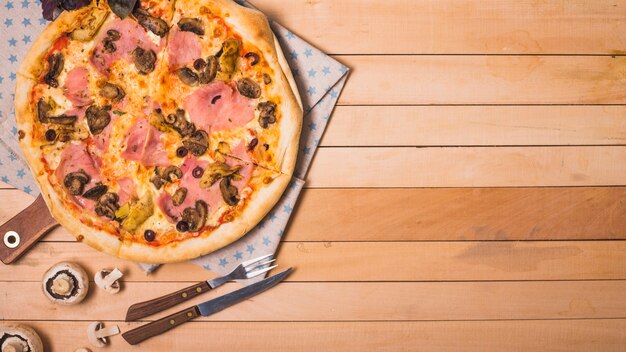 Une vue de dessus de pizza maison aux champignons sur une table en bois