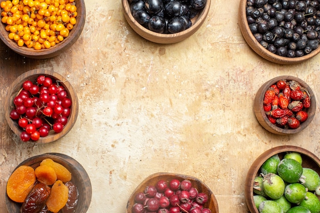 Vue de dessus de la place libre parmi divers fruits frais dans de petits pots bruns