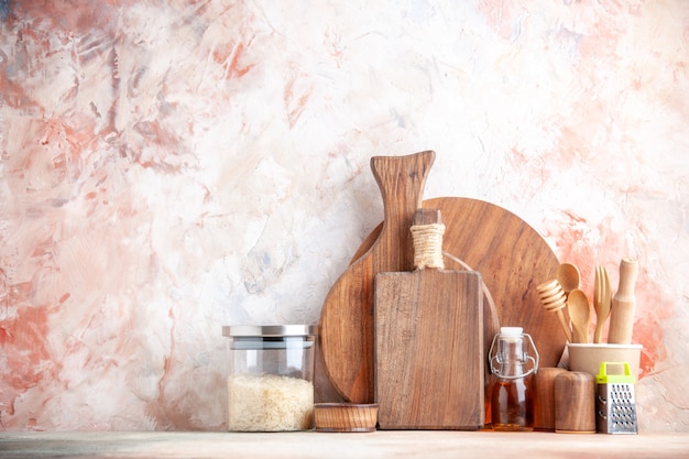 Vue de dessus de la planche à découper cuillères en bois râpe kumquats avec tige en pot et riz en verre sur une surface colorée