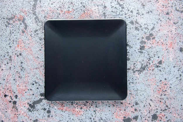 Vue de dessus plaque carrée noire sur fond clair service couverts dîner plateau de nourriture table de couleur restaurant