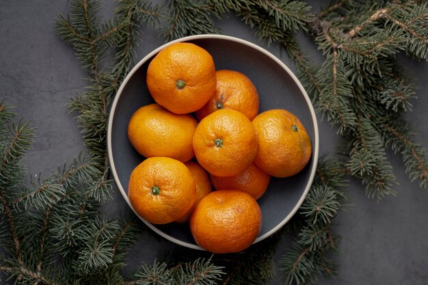 Vue de dessus de la plaque avec des mandarines et des pins