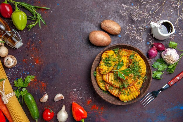 Vue de dessus un plat délicieux de pommes de terre cuites avec des légumes verts sur un plat de cuisson à surface sombre dîner de pommes de terre