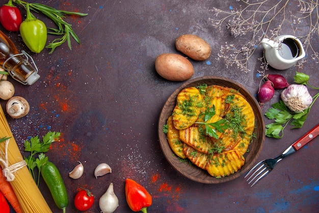 Vue de dessus un plat délicieux de pommes de terre cuites avec des légumes verts sur un plat de cuisson à surface sombre dîner de pommes de terre