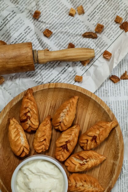 Vue de dessus plat traditionnel azerbaïdjanais gyurza frit avec du yaourt sur un plateau sur un journal