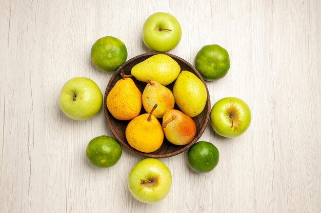 Vue de dessus poires douces fraîches fruits sucrés avec pommes et mandarines sur bureau blanc fruit jaune frais mûr sucré