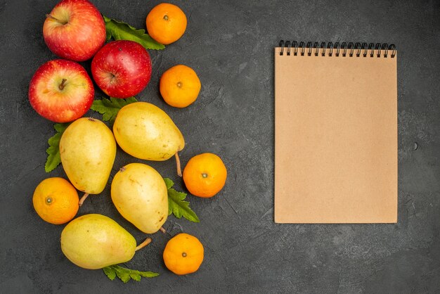 Vue de dessus des poires douces fraîches avec des mandarines et des pommes sur fond gris