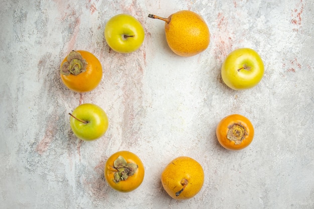 Photo gratuite vue de dessus des poires fraîches avec des kakis et des pommes sur des fruits de table blancs frais moelleux mûrs