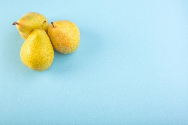 Une vue de dessus poires vertes pulpeuses douces fruits juteux et moelleux isolés sur le fond bleu glace fruits d'été exotique