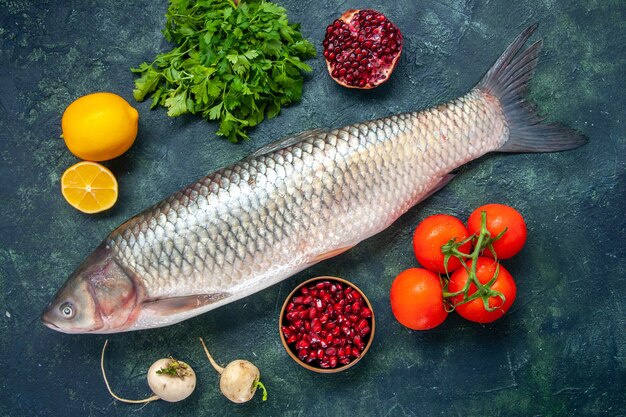 Vue de dessus poisson cru tomates radis persil grenade dans un petit bol citron sur table