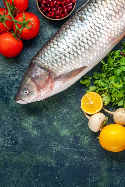 Photo gratuite vue de dessus poisson cru tomates radis persil grenade sel de mer dans de petits bols citron sur table