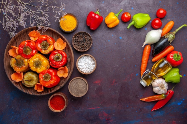 Vue de dessus poivrons cuits avec des légumes frais et des assaisonnements sur une surface grise repas dolma nourriture légumes viande de boeuf