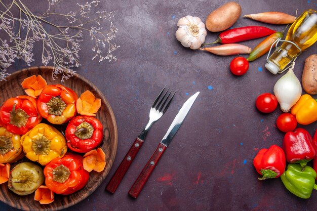 Vue de dessus poivrons cuits avec des légumes frais sur la surface gris foncé repas légumes viande dolma food