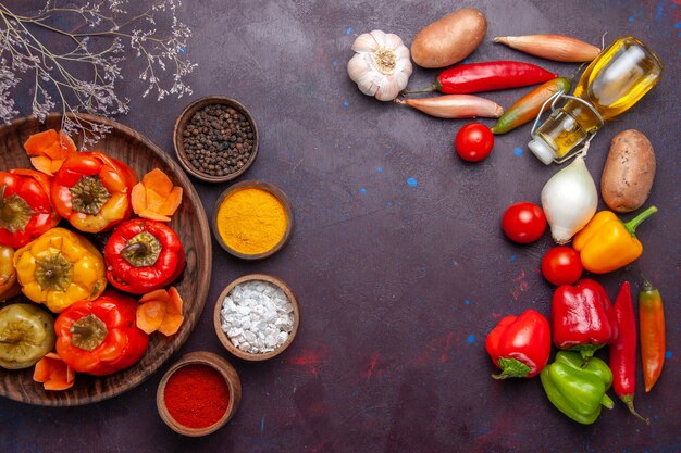 Vue de dessus poivrons cuits avec des légumes frais sur la surface gris foncé repas viande végétale dolma food