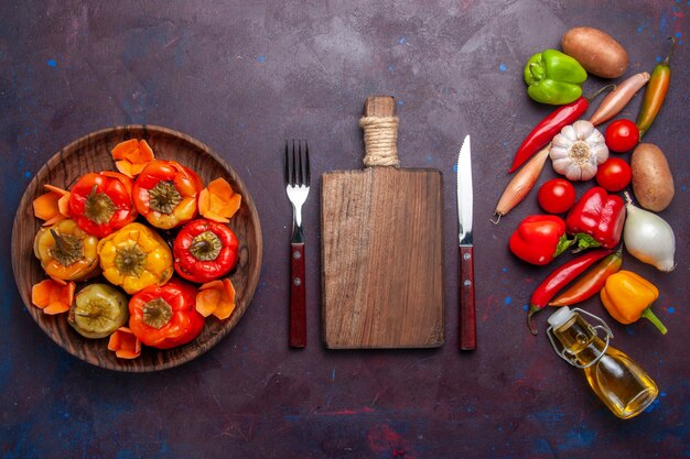 Vue de dessus des poivrons cuits avec des légumes frais sur la surface sombre des légumes repas viande dolma food