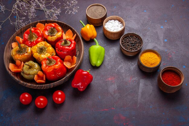 Vue de dessus poivrons cuits avec de la viande hachée et des assaisonnements sur la surface grise des légumes repas viande de boeuf