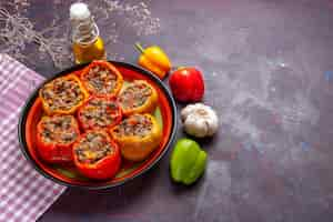 Photo gratuite vue de dessus des poivrons cuits avec de la viande hachée et de l'huile sur une surface sombre repas légumes nourriture viande dolma