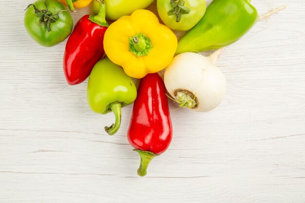 Vue de dessus de poivrons frais de différentes couleurs sur fond blanc couleur de salade de repas mûrs