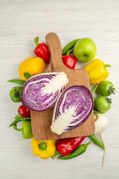 Vue de dessus des poivrons frais avec des pommes et du chou sur fond blanc, couleur mûre, vie saine, régime, salade