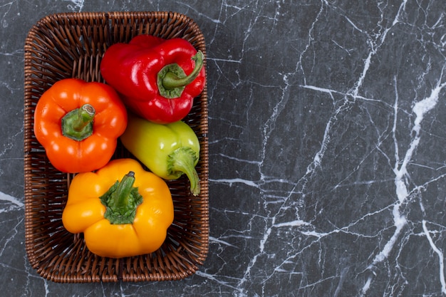 Photo gratuite vue de dessus des poivrons mûrs frais dans le panier tressé.