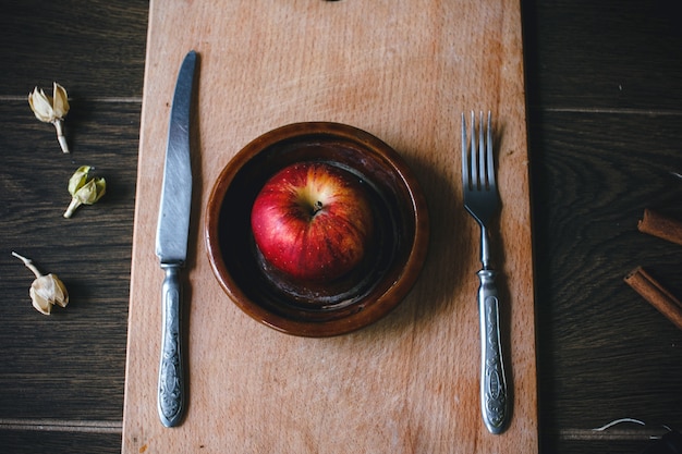 Vue de dessus de la pomme entre un couteau et une fourchette