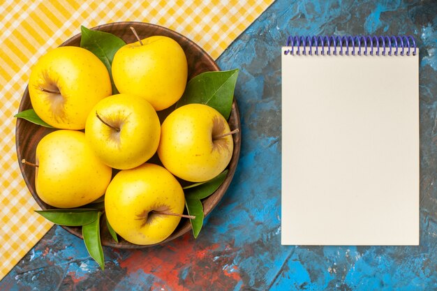 Vue de dessus des pommes douces fraîches à l'intérieur de la plaque sur fond bleu