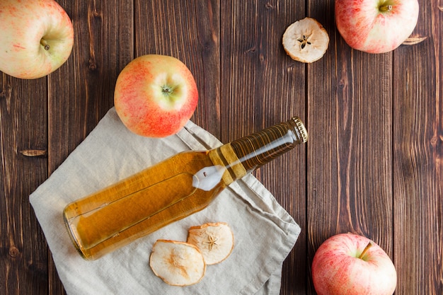 Vue de dessus des pommes avec du jus de pomme sur tissu et fond en bois. horizontal