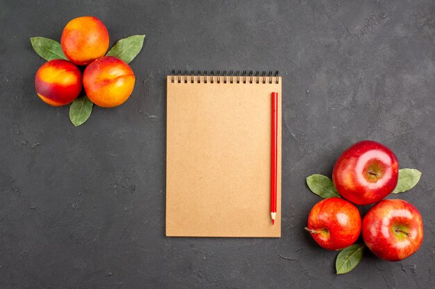 Vue de dessus des pommes fraîches aux pêches sur la table sombre couleur fruits frais mûrs