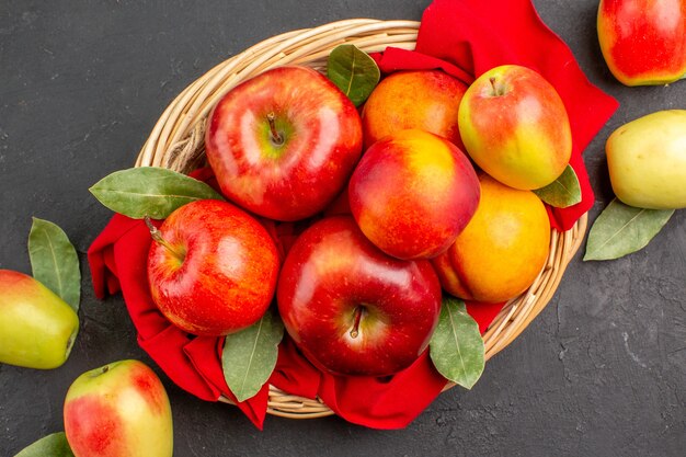 Vue de dessus des pommes fraîches aux pêches sur une table sombre jus moelleux de fruits mûrs