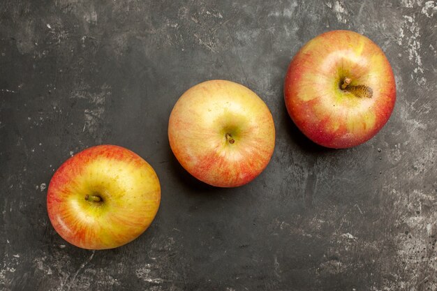 Vue de dessus des pommes fraîches bordées sur fond gris foncé