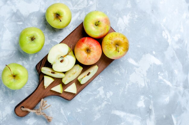 Vue de dessus des pommes fraîches coupées en tranches de fruits entiers sur la surface blanc clair