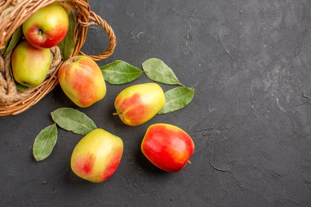 Vue de dessus pommes fraîches fruits mûrs à l'intérieur du panier sur la table grise fruits mûrs frais