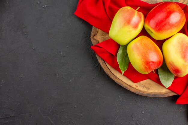Vue de dessus pommes fraîches fruits mûrs sur tissu rouge et table grise fruits mûrs frais