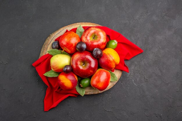 Vue de dessus des pommes fraîches avec des pêches et des prunes sur une table sombre jus moelleux d'arbre fruitier mûr