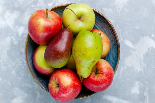 Vue de dessus des pommes de fruits frais et de la mangue sur le bureau blanc clair