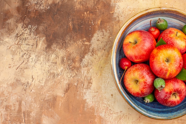 Vue de dessus des pommes rouges fraîches avec des feijoas à l'intérieur du plateau