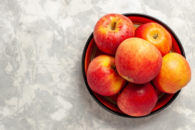 Vue de dessus pommes rouges fraîches fruits moelleux sur surface blanche