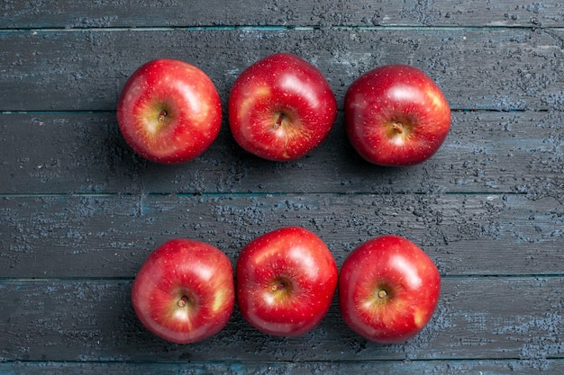 Vue de dessus des pommes rouges fraîches des fruits mûrs moelleux sur un bureau bleu foncé couleur des fruits des plantes rouge vitamine frais