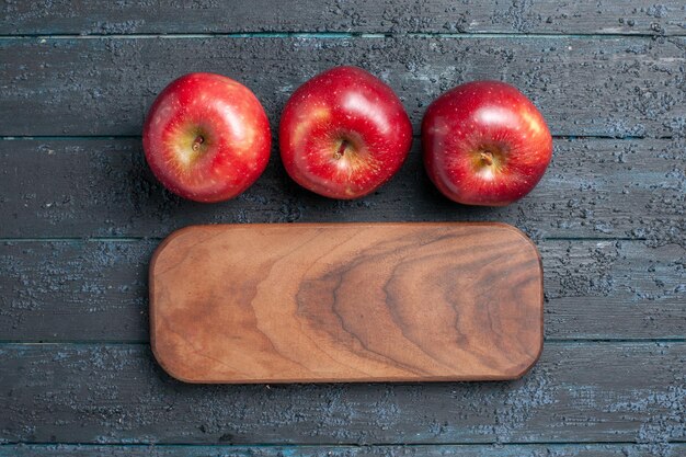 Vue de dessus des pommes rouges fraîches des fruits mûrs moelleux sur un bureau bleu foncé couleur des fruits des plantes rouge vitamine frais