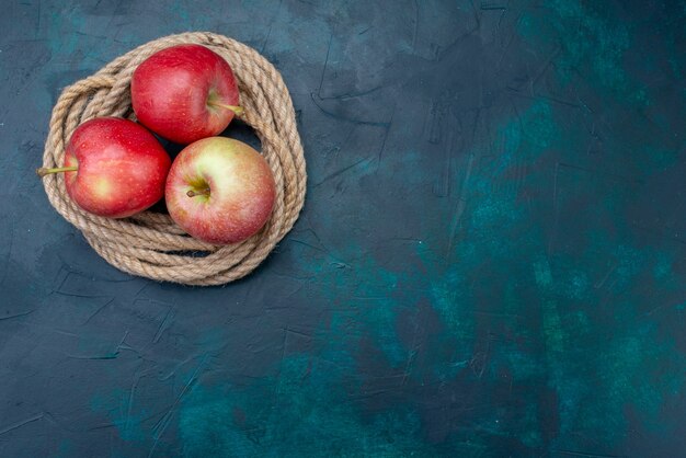 Vue de dessus pommes rouges fraîches juteuses et moelleuses sur fond bleu foncé fruits mûrs vitamine fraîche