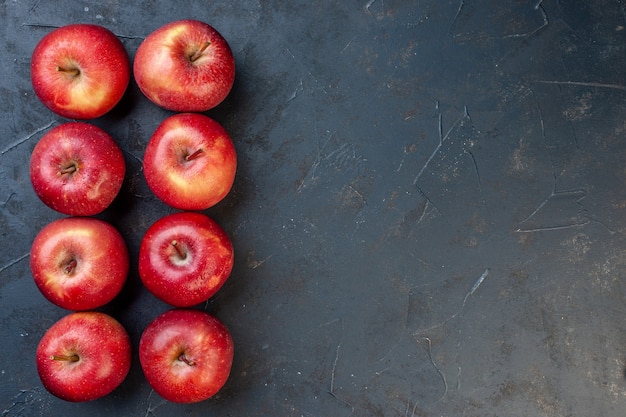 Vue de dessus des pommes rouges fraîches sur une table sombre avec place libre