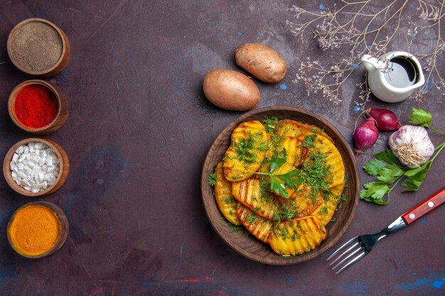 Vue de dessus de pommes de terre cuites plat délicieux avec des verts sur un bureau sombre plat de repas de cuisine dîner de pommes de terre