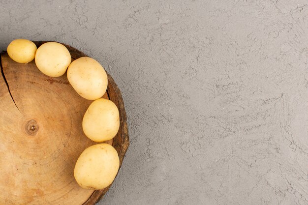 Photo gratuite vue de dessus des pommes de terre pelées sur le sol gris