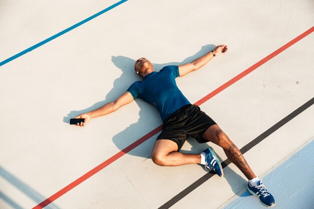 Vue de dessus portrait d'un jeune homme africain fatigué de remise en forme au repos