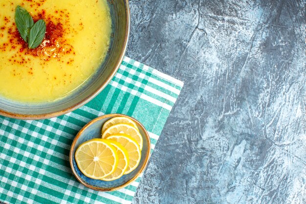 Vue de dessus d'un pot bleu avec une soupe savoureuse servie avec de la menthe sur fond bleu